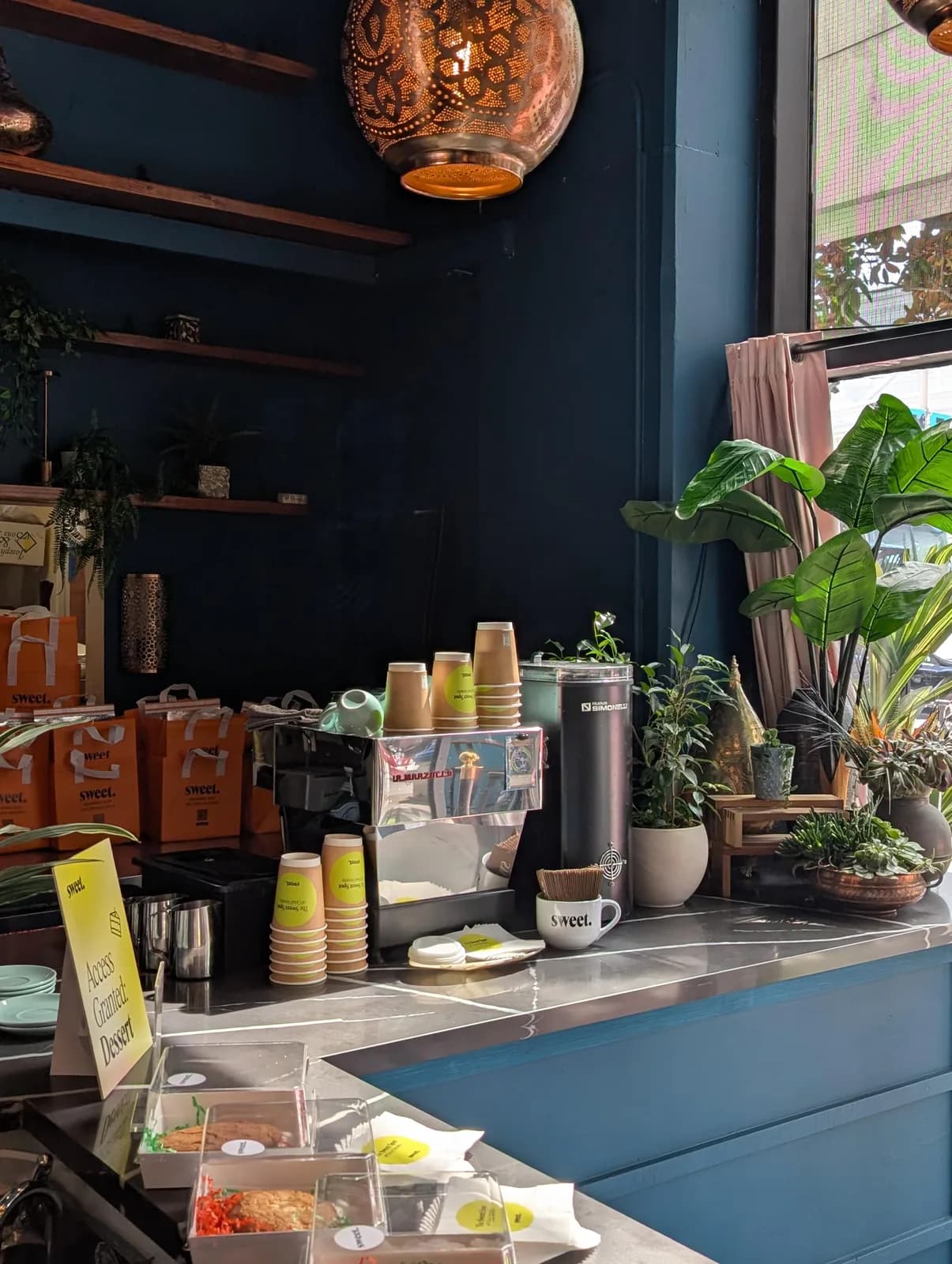 Paper Son’s mobile espresso bar at a catered event, with stacked cups and pastries on the counter