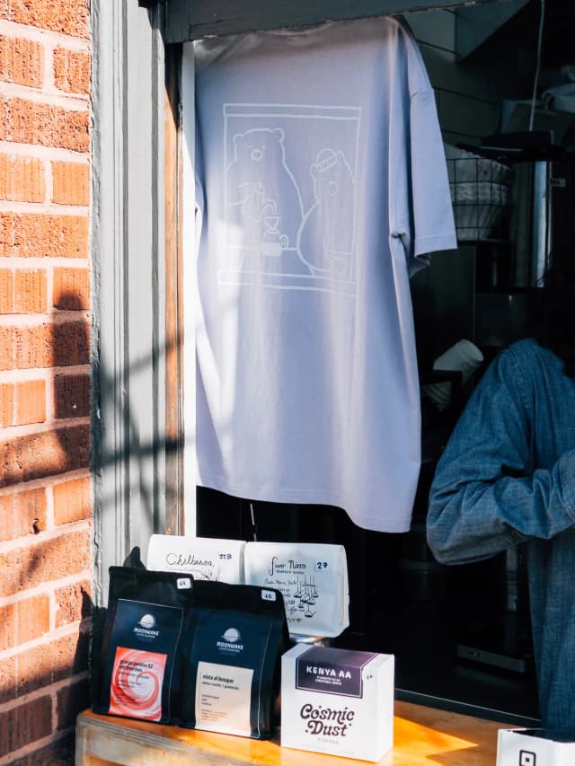 A Paper Son t-shirt hanging in the shop window.